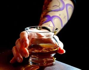 Guy with tattoo drinking from NEAT Glass